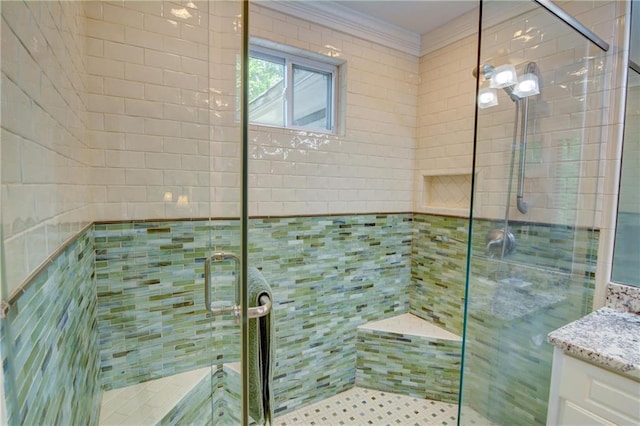 full bath featuring crown molding, vanity, and a stall shower