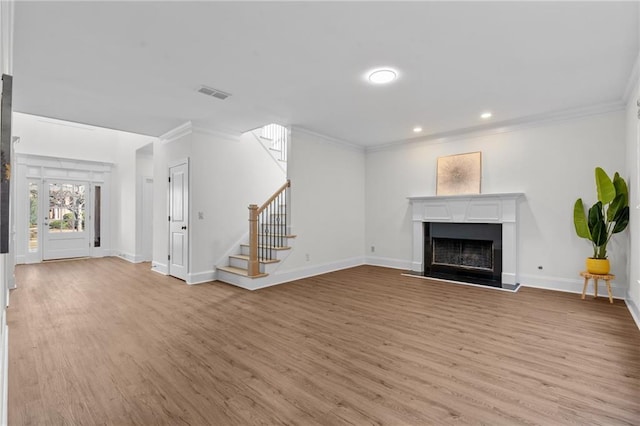 unfurnished living room with light wood finished floors, visible vents, stairway, crown molding, and a fireplace