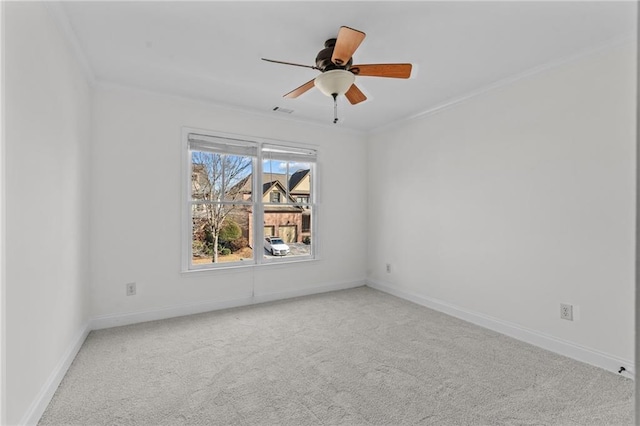 carpeted empty room featuring ornamental molding, visible vents, baseboards, and a ceiling fan