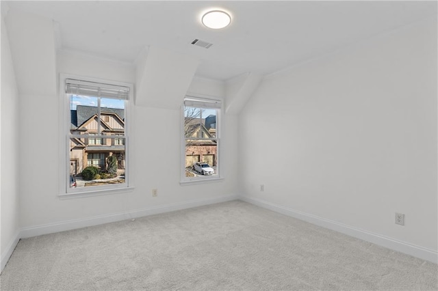 spare room with crown molding, carpet, visible vents, and baseboards