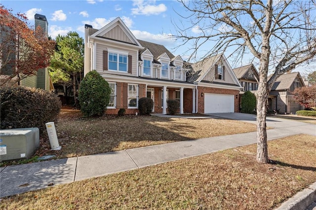 traditional home featuring a garage, brick siding, board and batten siding, and concrete driveway