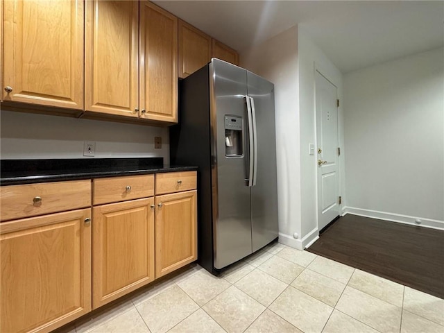 195 14th St NE Unit 303, Atlanta, GA 30309 - kitchen featuring stainless steel fridge with ice dispenser, light tile patterned floors, and dark countertops