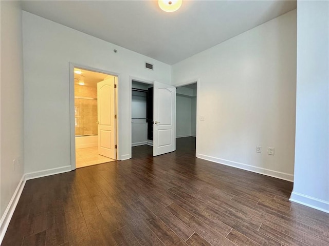 195 14th St NE Unit 303, Atlanta, GA 30309 - unfurnished bedroom featuring dark wood-style floors, connected bathroom, and a closet