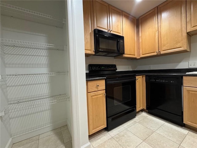 195 14th St NE Unit 303, Atlanta, GA 30309 - kitchen with black appliances, dark countertops, and light tile patterned flooring