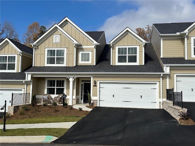 craftsman inspired home with a porch, a garage, a shingled roof, driveway, and board and batten siding