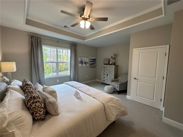 spare room with carpet floors, visible vents, baseboards, ornamental molding, and a raised ceiling