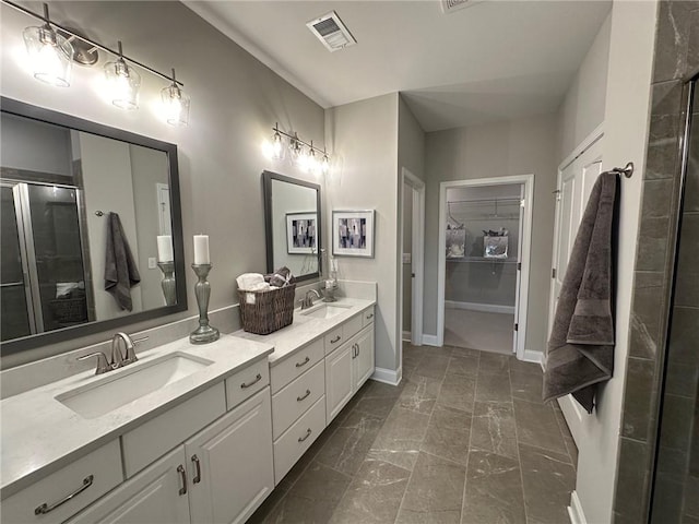 full bathroom with visible vents, a sink, a shower with door, and double vanity