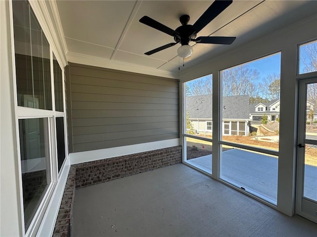 unfurnished sunroom featuring ceiling fan