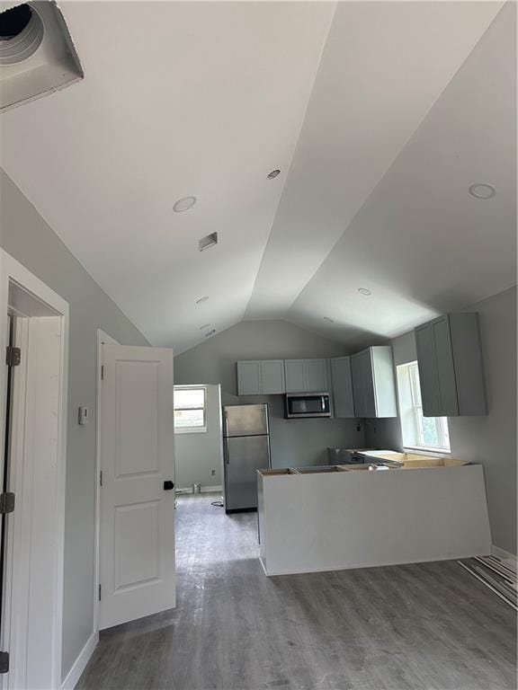 kitchen featuring appliances with stainless steel finishes, wood-type flooring, lofted ceiling, and gray cabinetry