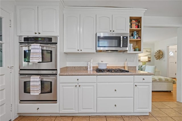 3357 Pretty Branch Dr SE, Smyrna, GA 30080 - kitchen with stainless steel appliances, white cabinets, light tile patterned floors, open shelves, and light stone countertops