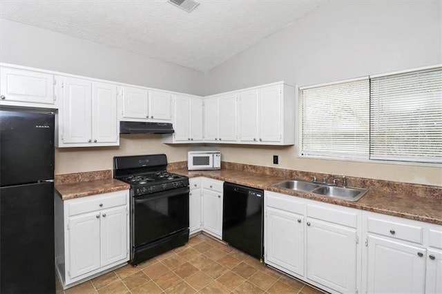 kitchen featuring vaulted ceiling, white cabinetry, sink, black appliances, and a textured ceiling