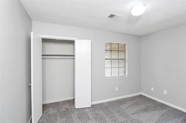 unfurnished bedroom featuring carpet, a textured ceiling, and a closet