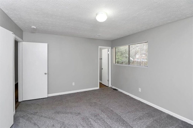 carpeted empty room with a textured ceiling