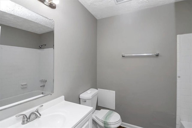 full bathroom featuring vanity, tub / shower combination, toilet, and a textured ceiling