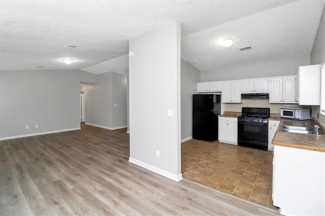 kitchen with lofted ceiling, sink, white cabinets, light hardwood / wood-style floors, and black appliances