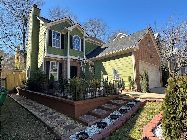 view of front facade featuring an attached garage, fence, brick siding, and a chimney