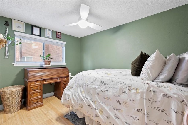 bedroom with light wood-type flooring, a textured ceiling, and ceiling fan