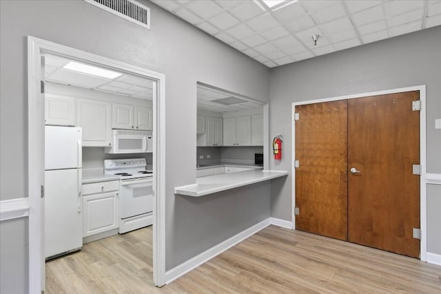 kitchen featuring white cabinetry, white appliances, a paneled ceiling, and light hardwood / wood-style flooring