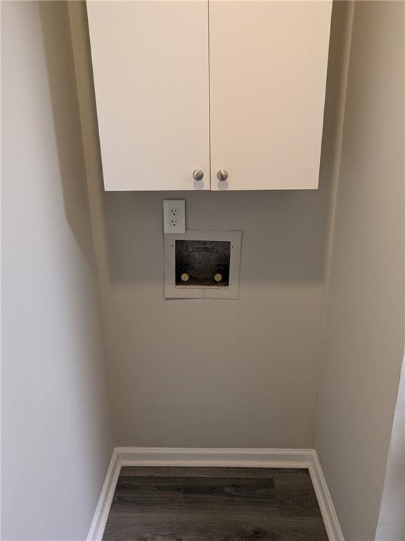 laundry room with dark wood-type flooring, hookup for a washing machine, and cabinets