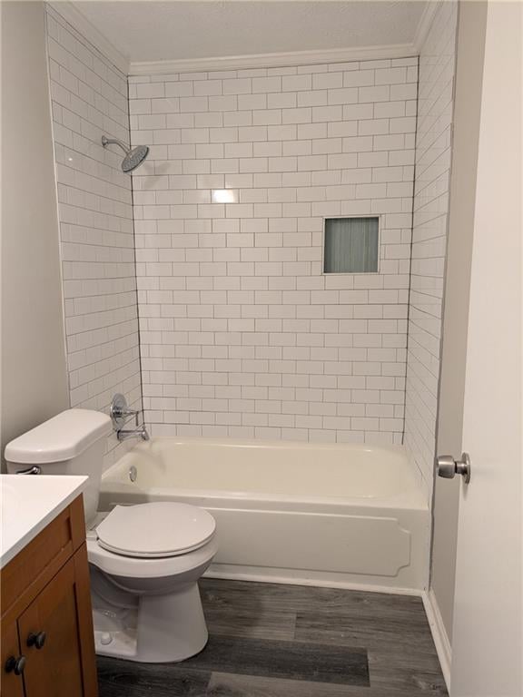 full bathroom featuring vanity, crown molding, toilet, hardwood / wood-style flooring, and tiled shower / bath combo