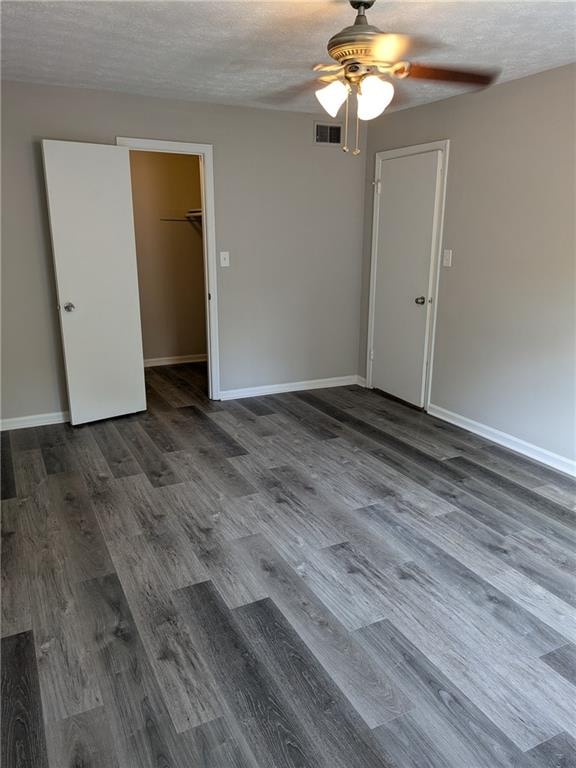 spare room with ceiling fan, dark hardwood / wood-style flooring, and a textured ceiling