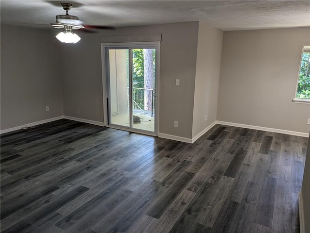 spare room featuring dark wood-type flooring, plenty of natural light, and ceiling fan