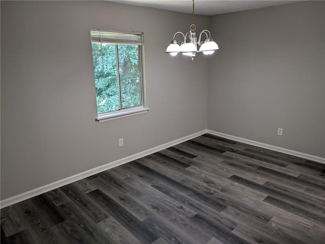 unfurnished room with a chandelier and dark hardwood / wood-style flooring