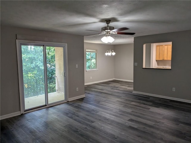 spare room featuring ceiling fan with notable chandelier and dark hardwood / wood-style flooring