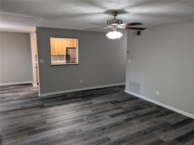 empty room featuring ceiling fan and dark hardwood / wood-style flooring