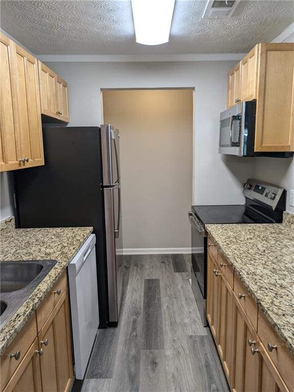 kitchen featuring a textured ceiling, stainless steel appliances, light stone countertops, and dark hardwood / wood-style floors