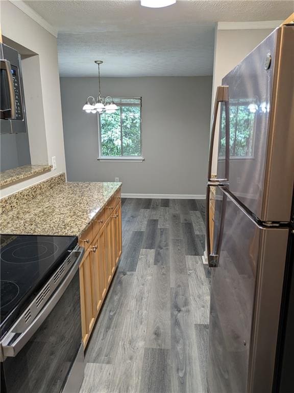 kitchen featuring a textured ceiling, dark hardwood / wood-style floors, light stone countertops, a notable chandelier, and appliances with stainless steel finishes