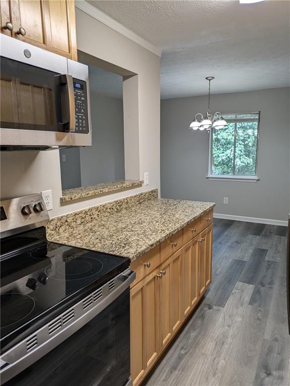 kitchen featuring light stone counters, stainless steel appliances, a chandelier, dark hardwood / wood-style flooring, and kitchen peninsula