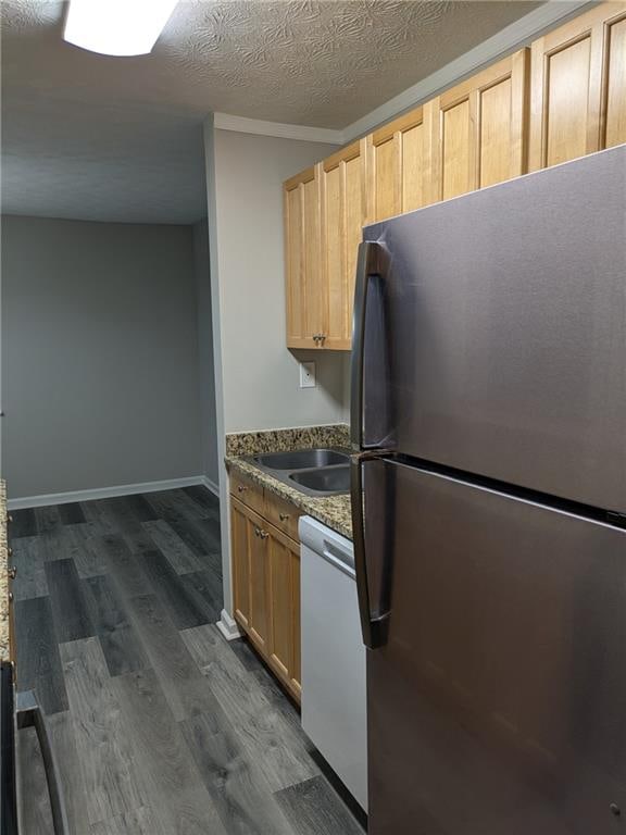 kitchen with white dishwasher, stainless steel fridge, light brown cabinets, dark wood-type flooring, and a textured ceiling