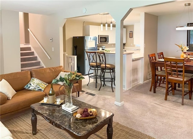 2917 Duncan Pl, Decatur, GA 30034 - living room with arched walkways, light carpet, and stairway