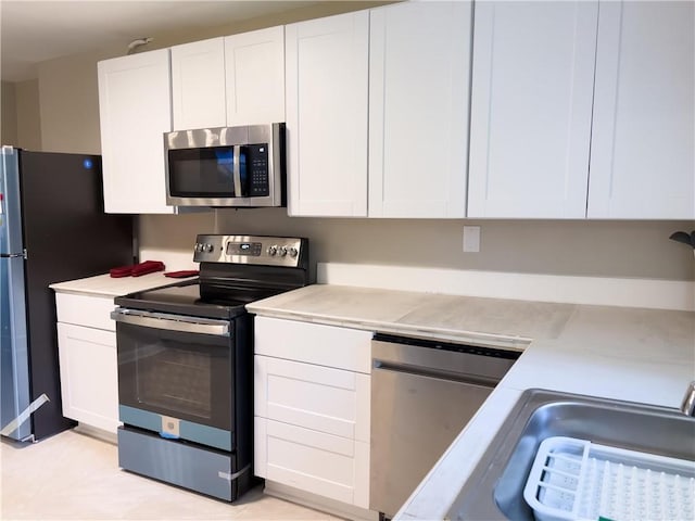 2917 Duncan Pl, Decatur, GA 30034 - kitchen with appliances with stainless steel finishes, light countertops, and white cabinetry