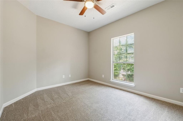 empty room with carpet flooring, ceiling fan, and a healthy amount of sunlight