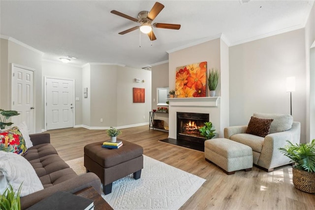 living room with ceiling fan, light wood-type flooring, and crown molding