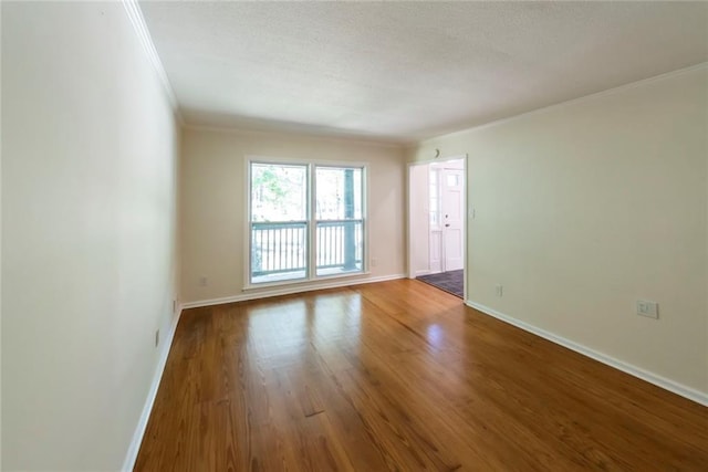 empty room with hardwood / wood-style flooring and ornamental molding