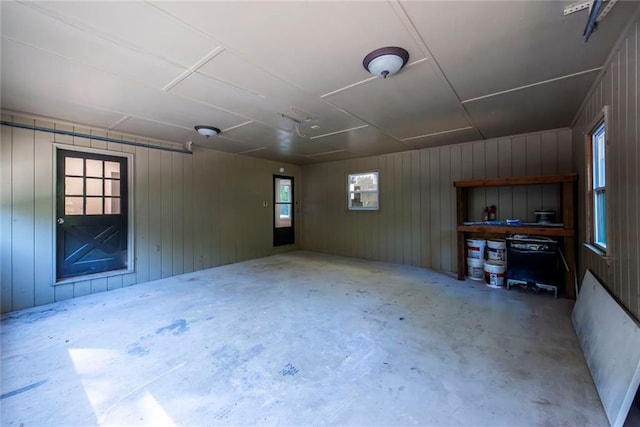 empty room with concrete floors and wood walls