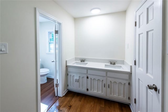 bathroom with hardwood / wood-style flooring, vanity, and toilet