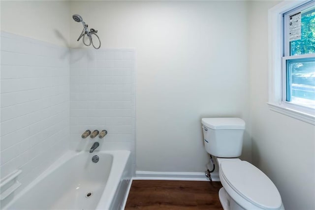 bathroom with hardwood / wood-style flooring, bathtub / shower combination, and toilet