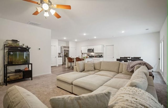 living room with light hardwood / wood-style floors and ceiling fan