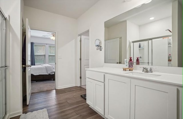 bathroom with hardwood / wood-style flooring, ceiling fan, vanity, and walk in shower