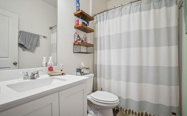 bathroom with walk in shower, vanity, and toilet