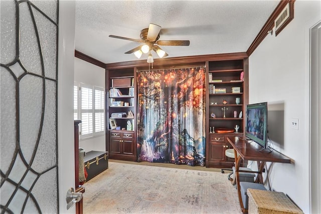 office with visible vents, a textured ceiling, a ceiling fan, and crown molding