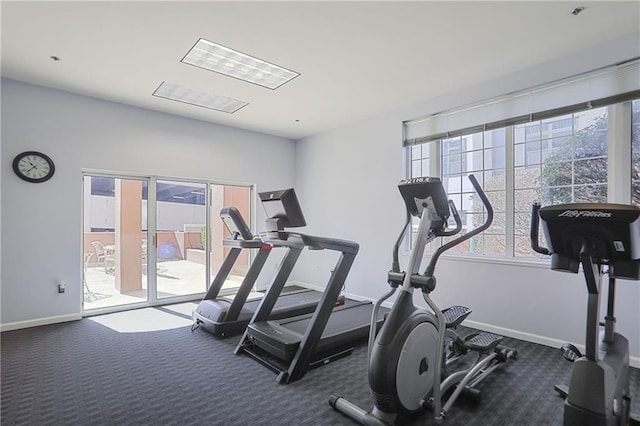 exercise room with plenty of natural light, carpet flooring, and baseboards