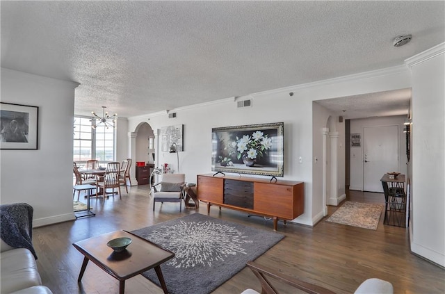 living room with arched walkways, a chandelier, wood finished floors, visible vents, and crown molding