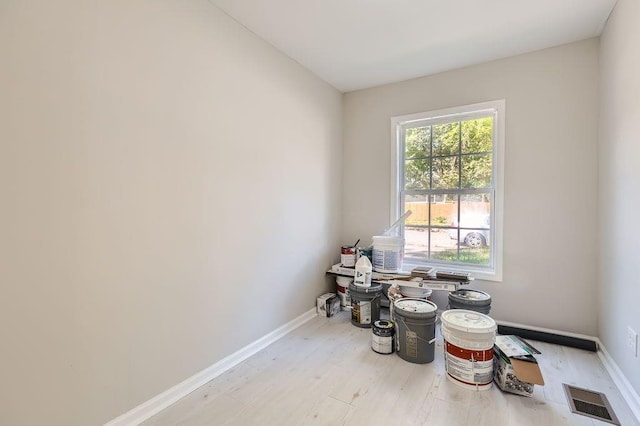 interior space featuring baseboards, wood finished floors, and visible vents