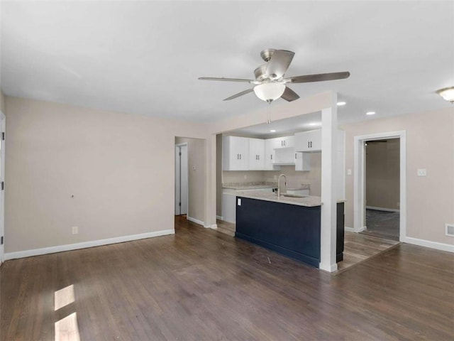 unfurnished living room with ceiling fan, sink, and dark hardwood / wood-style flooring