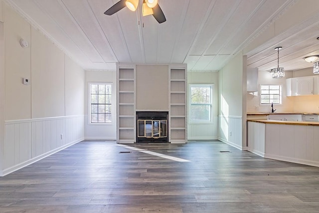 unfurnished living room with wood ceiling, ceiling fan, dark hardwood / wood-style flooring, and sink